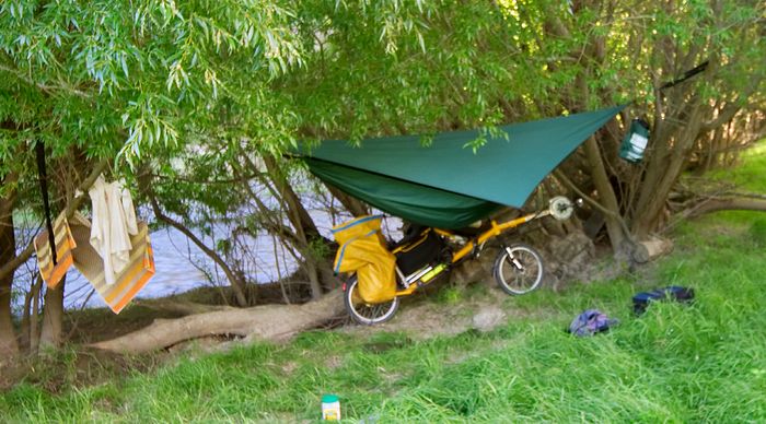 I camped down underneath it, taking the panniers and stuff off my bike to get it over the fence, then reassembling it to ride down a track to the creek. Lots of thistles  then this rather nice campsite, sheltered from the weather as well as hard to see from the track. The towel indicates that I had a brief wash in the creek, but I'm not a swimmer unless the water is over 25 degrees.